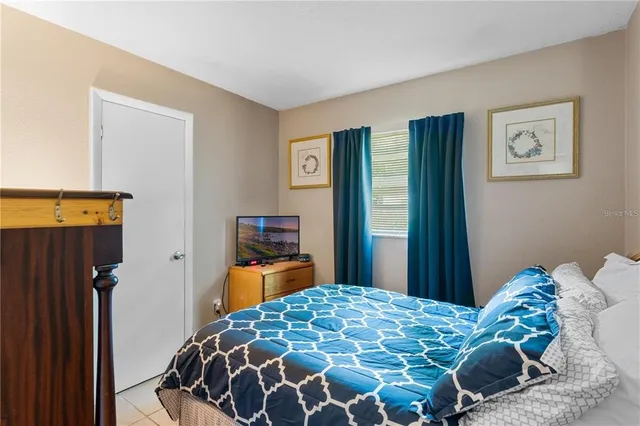 a bedroom with a bed and a lamp on dresser