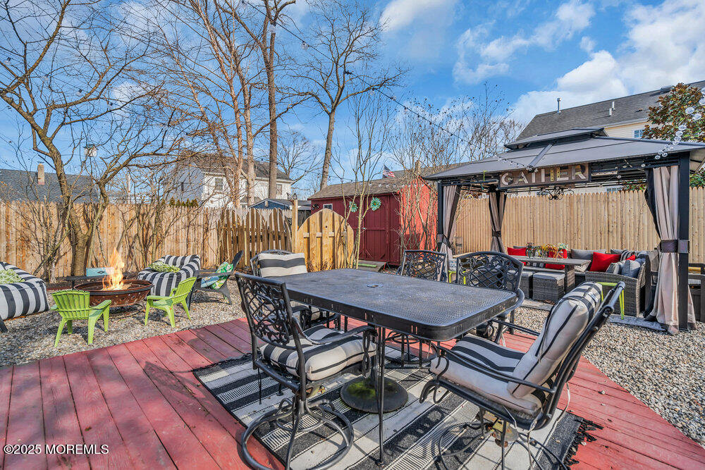 506 Crestview Terrace Point Pleasant, NJ 08742 - Photo 20 of 24 a view of a patio with table and chairs with wooden floor and fence