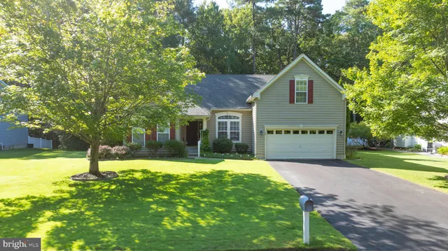 a front view of a house with a yard and trees