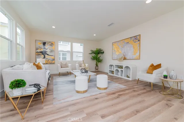 a view of a dining room with furniture a potted plant and wooden floor