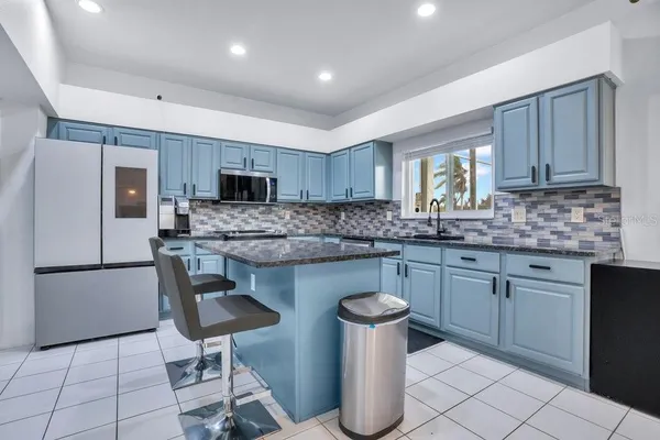 a kitchen with stainless steel appliances granite countertop a refrigerator and a stove top oven