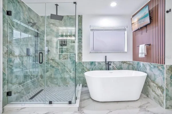 a large bathroom with a tub sink shower and mirror