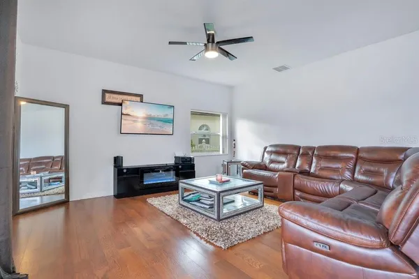 a living room with furniture and a wooden floor