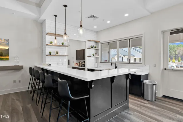 a kitchen with stainless steel appliances kitchen island a island a stove a table and chairs in it