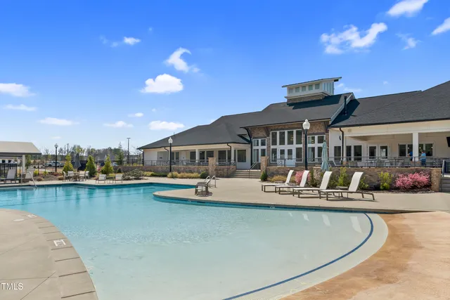 a view of a house with swimming pool and sitting area