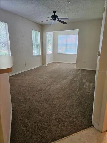 en empty room with windows and fan