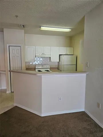 a room with stainless steel appliances granite countertop a refrigerator a stove a sink and a microwave