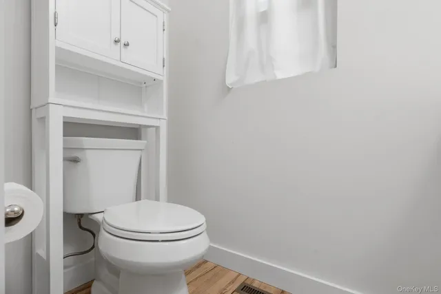 a white toilet sitting next to a shower