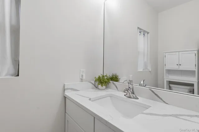 a bathroom with a granite countertop sink and a mirror