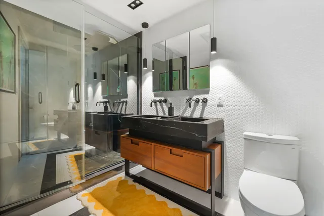 a bathroom with a sink a toilet and shower