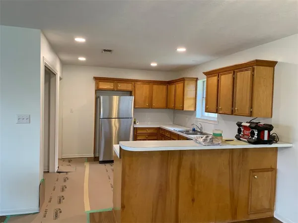 a kitchen with stainless steel appliances granite countertop a sink refrigerator and cabinets