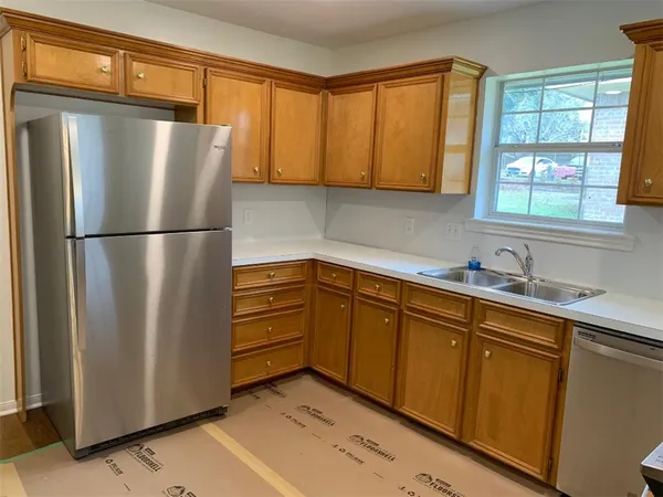 a kitchen with stainless steel appliances granite countertop a refrigerator a sink and cabinets