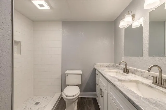 a bathroom with a granite countertop sink a toilet and a mirror