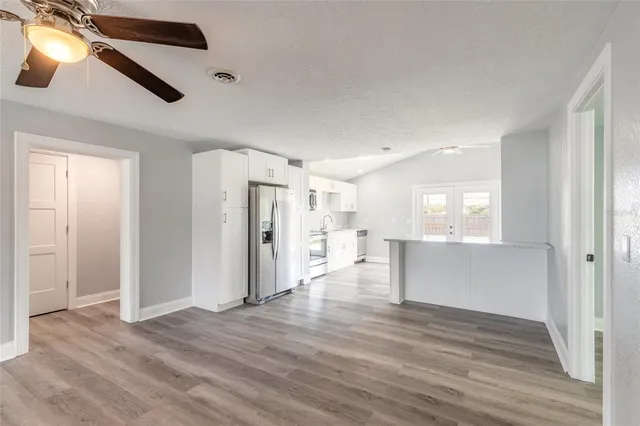 a view of a livingroom with wooden floor and a ceiling fan