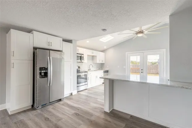 a kitchen with stainless steel appliances a refrigerator and a stove top oven