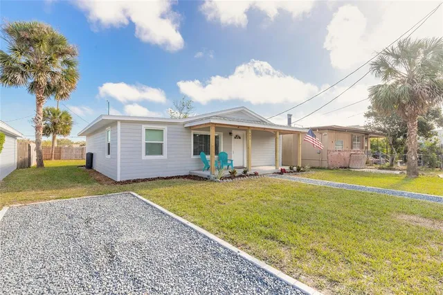 a view of a house with backyard and a tree