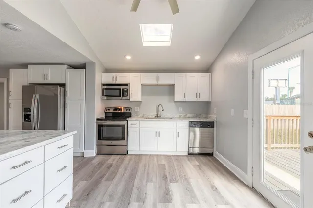 a kitchen with granite countertop cabinets stainless steel appliances and a window
