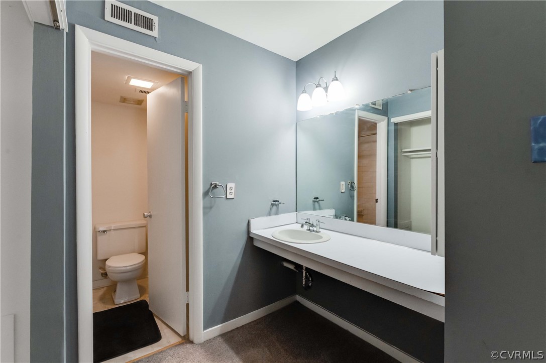 10292 Iron Mill Road North Chesterfield, VA 23235 - Photo 18 of 24 a bathroom with a sink a toilet and a mirror