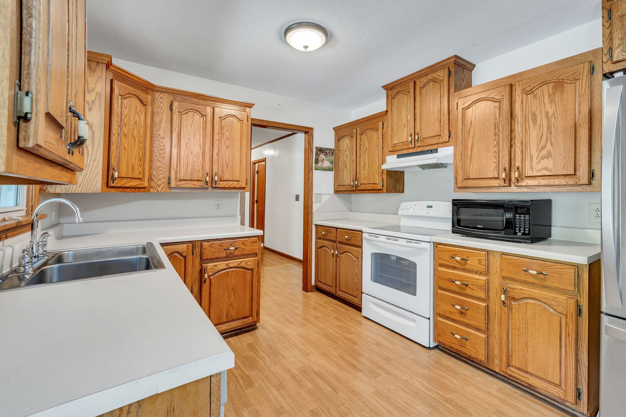 922 Hayes Road Lawrenceburg, TN 38464 - Photo 12 of 36 a kitchen with stainless steel appliances granite countertop a stove a sink dishwasher and a refrigerator with wooden cabinets