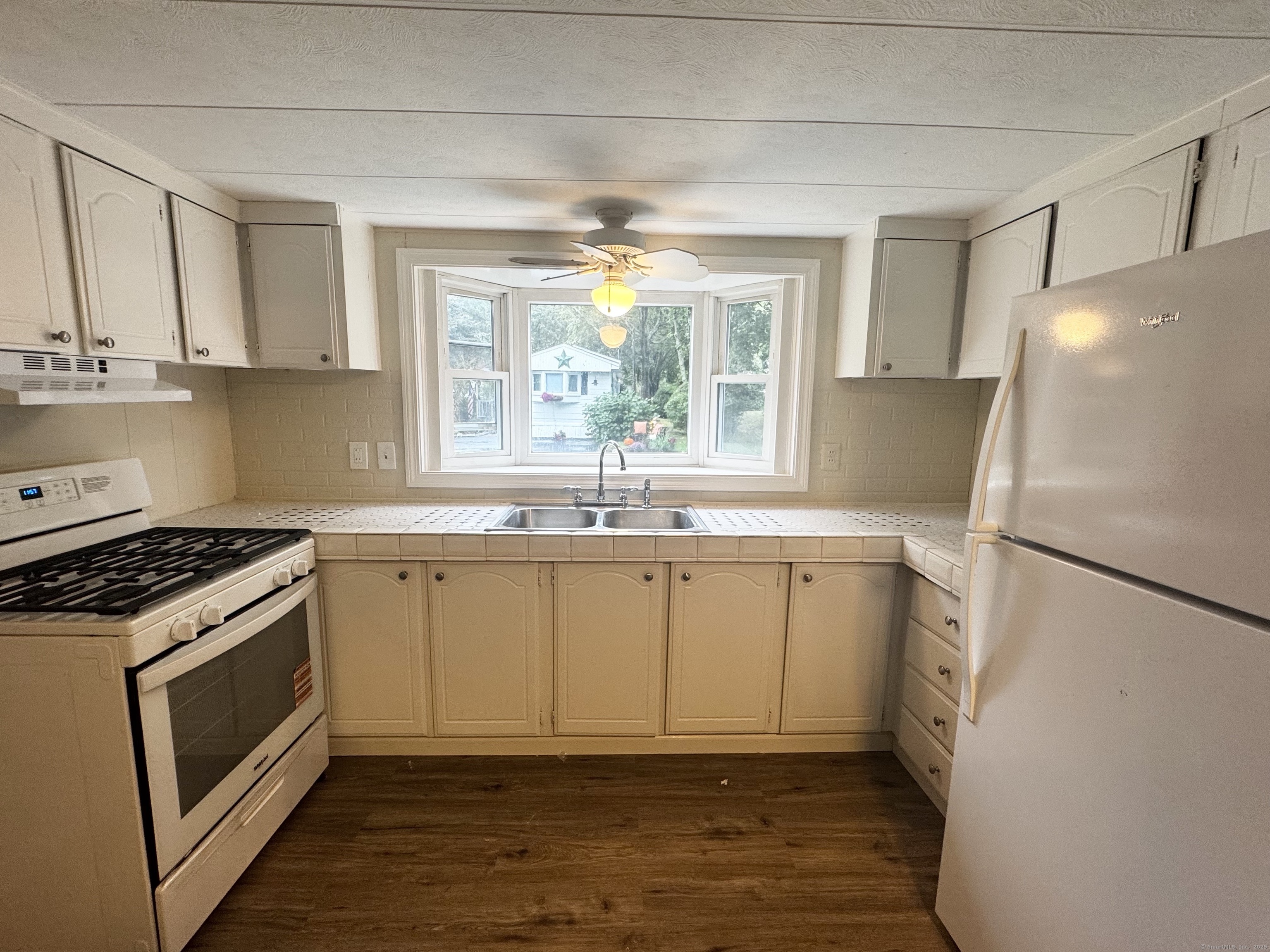 33 Whitewood Road Killingworth, CT 06419 - Photo 5 of 8 a kitchen with a sink a refrigerator a window and cabinets