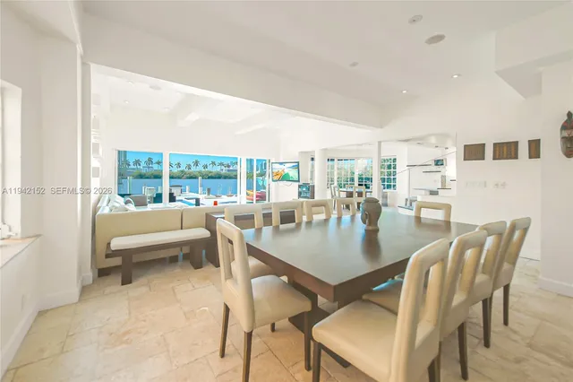 a dining room with furniture and a large window
