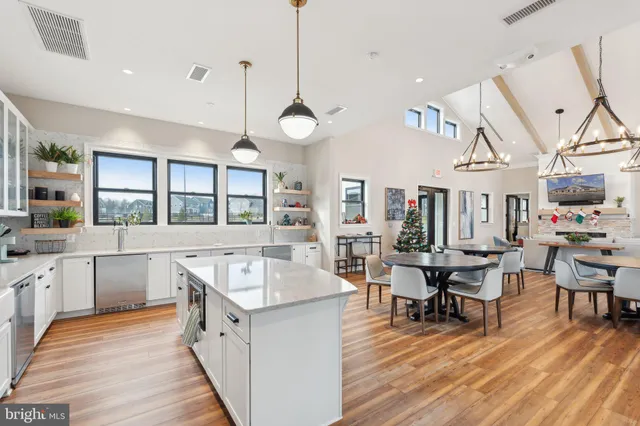 a large white kitchen with stainless steel appliances lots of counter space and a sink