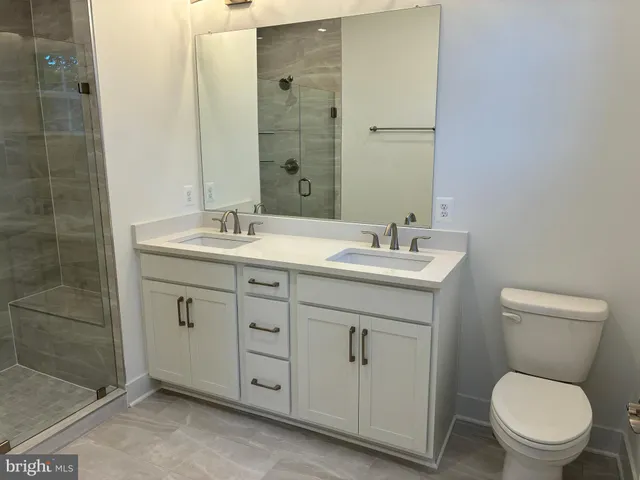a bathroom with a toilet sink vanity and mirror