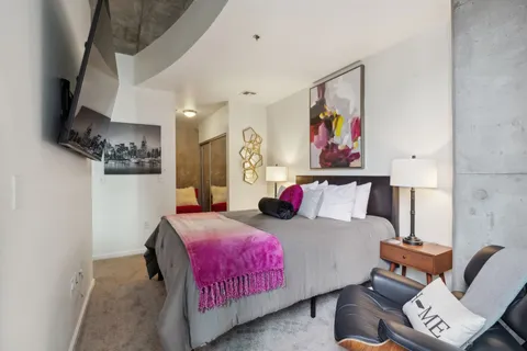 a bedroom with a bed and a painting on the wall