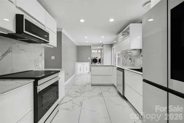 a kitchen with stainless steel appliances a refrigerator sink and microwave