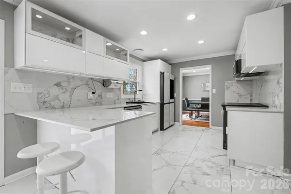 a kitchen with stainless steel appliances granite countertop a sink and a refrigerator