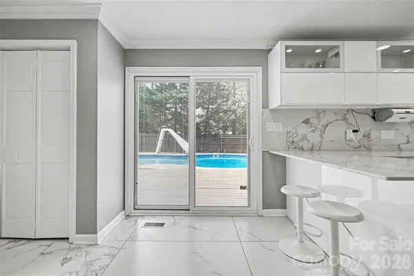 a kitchen with a sink a stove and white cabinets with wooden floor