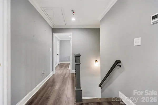a view of a hallway with wooden floor and staircase