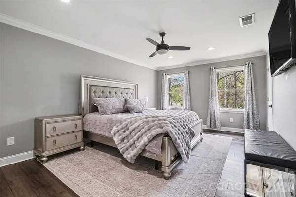 a spacious bedroom with a bed a window and a flat screen television