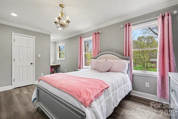 a bedroom with a large bed and a chandelier
