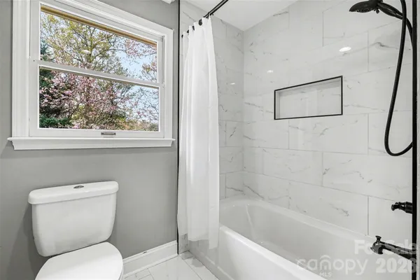 a white toilet sitting next to a bath tub shower