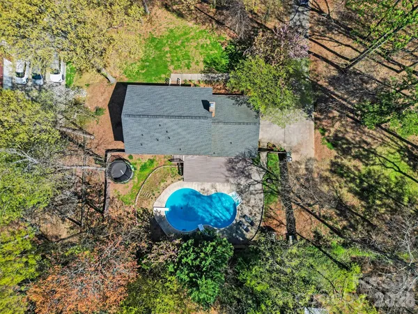 an aerial view of a house with a yard and large trees