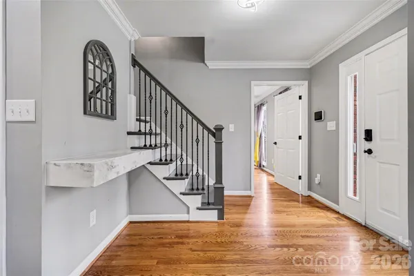 a view of entryway and hall with wooden floor
