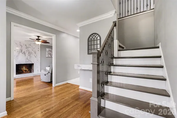 a view of an entryway with wooden floor and a fireplace