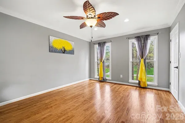 a view of an empty room with window and wooden floor