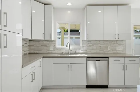 a kitchen with granite countertop white cabinets and white appliances