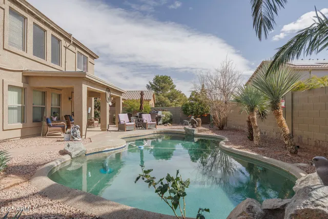 a view of a backyard with swimming pool