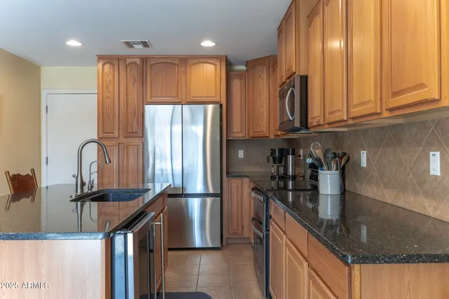 a kitchen with stainless steel appliances granite countertop a refrigerator and a sink