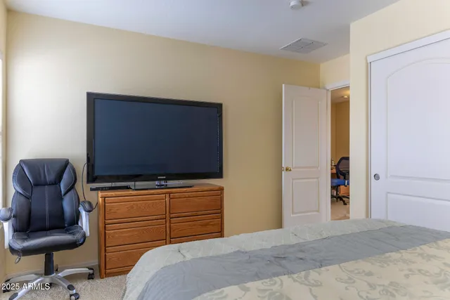 a bedroom with a chair and television