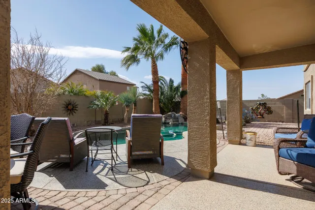 a view of a patio with table and chairs potted plants and a palm tree