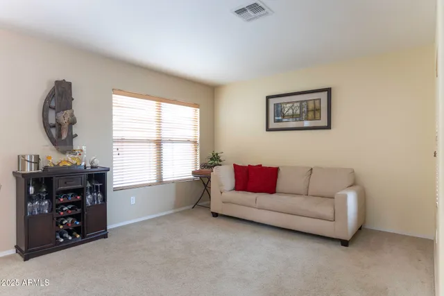 a living room with furniture a large window and a potted plant
