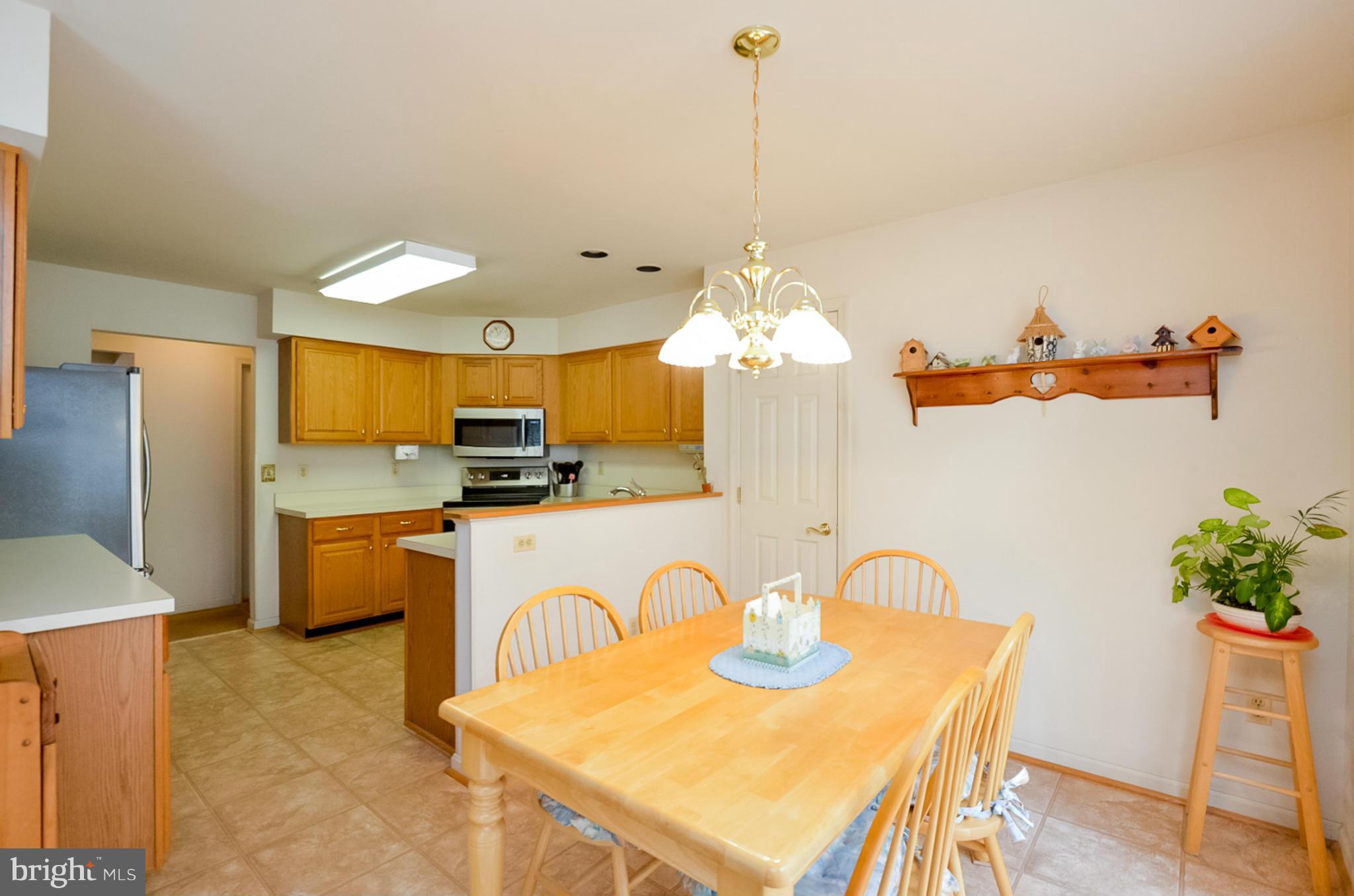 575 Pasture Brook Road Severn, MD 21144 - Photo 9 of 29 a kitchen with stainless steel appliances granite countertop a dining table and a refrigerator