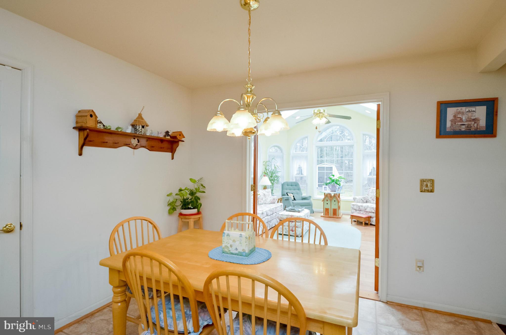 575 Pasture Brook Road Severn, MD 21144 - Photo 10 of 29 a dining room with furniture a chandelier and window