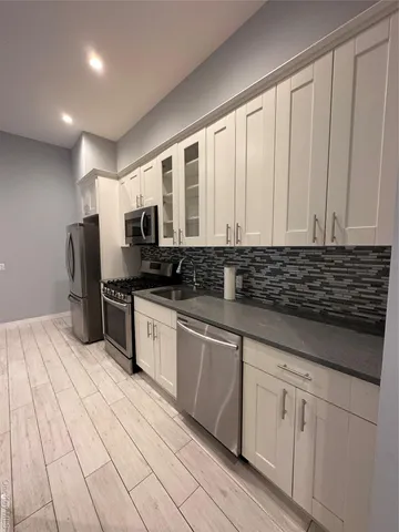 a kitchen with stainless steel appliances granite countertop a sink and cabinets
