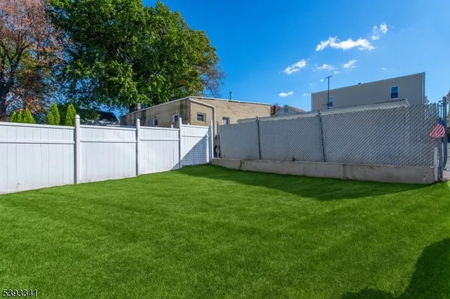 a view of a backyard with potted plants and large trees