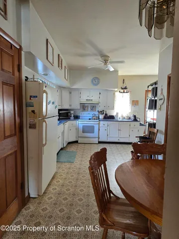 a kitchen with refrigerator and chairs
